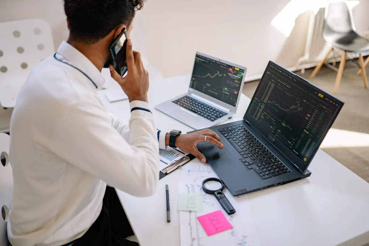 Someone working at a desk with a laptop and notes
