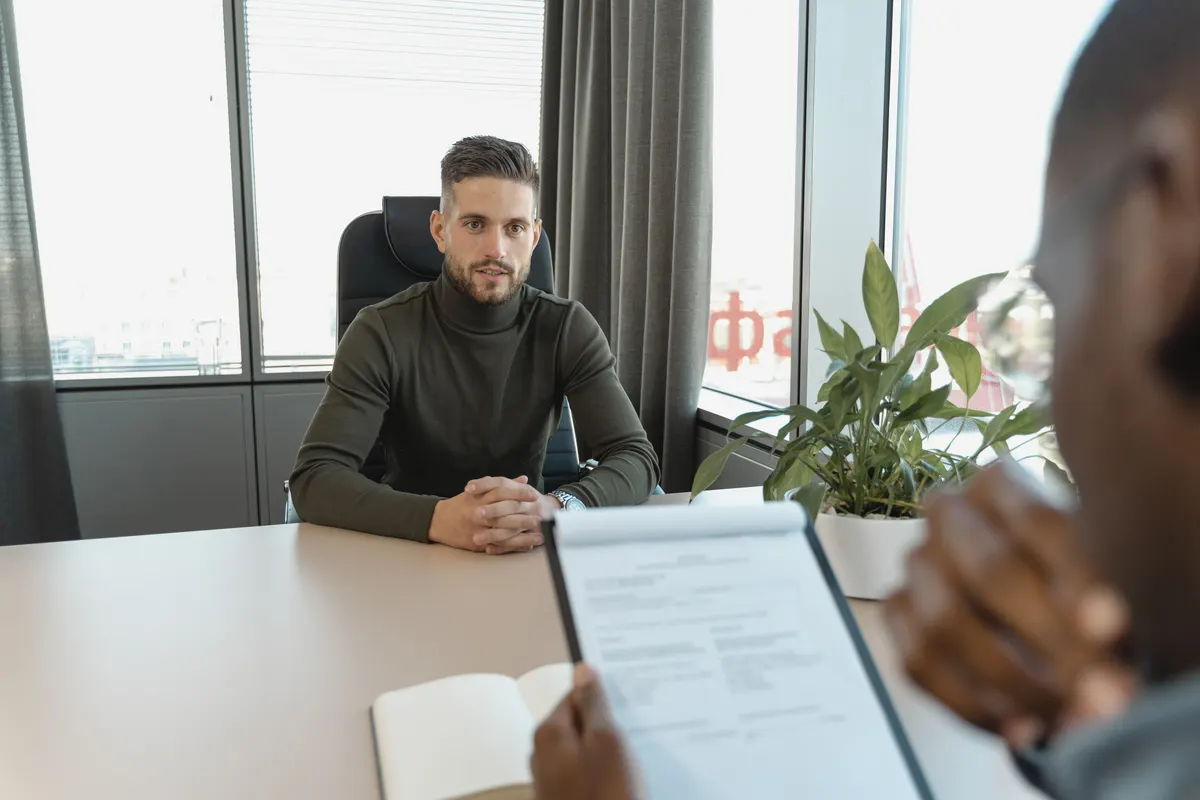 Two people talking across a desk in an office