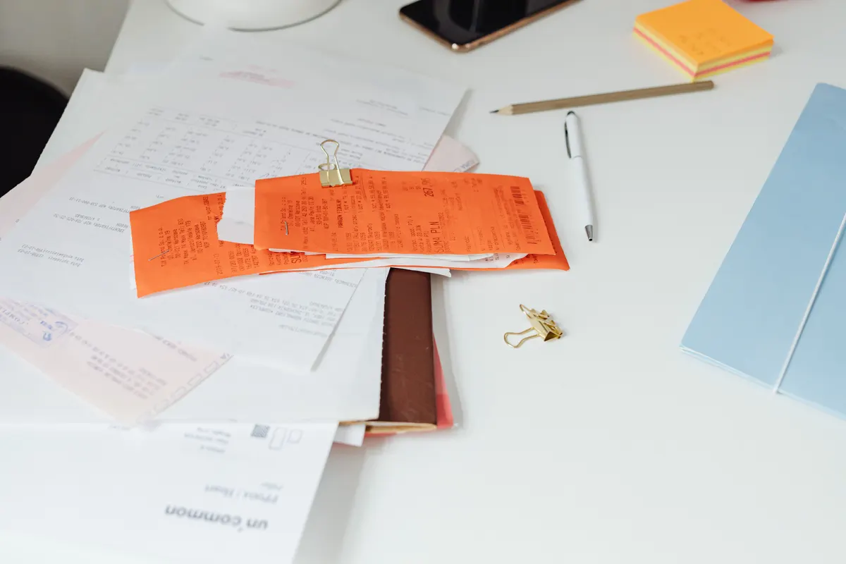 Application forms, notes and a pen laid out on a desk