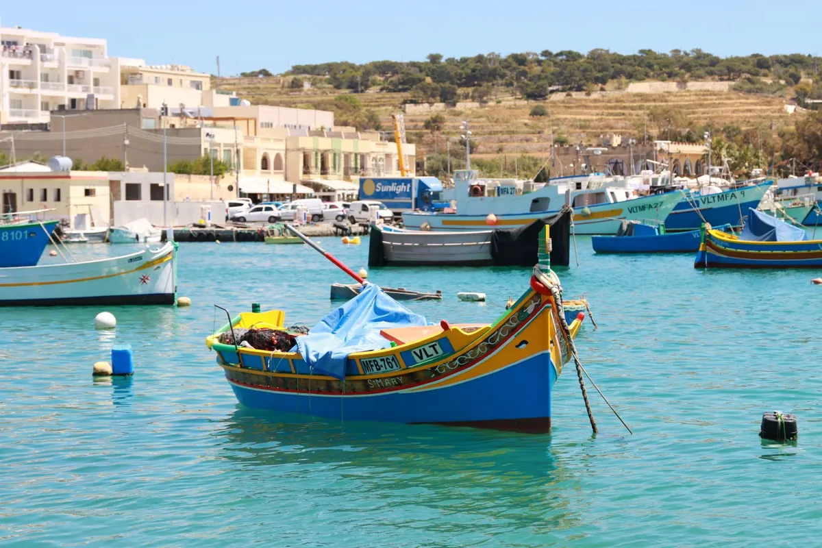 Brightly painted luzzu fishing boats moored in a Maltese harbour