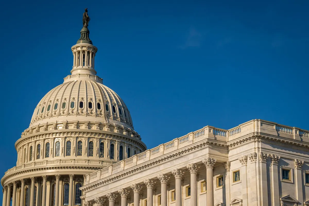 The dome of the US Capitol in Washington, DC against a deep blue sky